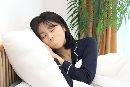 코로만 숨 쉬기 위해 입술에 반창고를 붙이고 누운 여성. /티에스