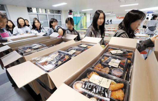 16일 급식 중단 사태를 겪고 있는 대전 중구 글꽃중에서 학생들이 줄지어 학교 측이 임시 제공한 도시락을 받고 있다. 이 학교는 급식 조리원들이 미역 자르기와 계란 까기 등 까다로운 식재료 손질 업무를 거부해 ‘미역 없는 미역국’이 제공되는 등 파행을 겪다가 조리원들이 단체 병가를 내 급식이 중단됐다./신현종 기자