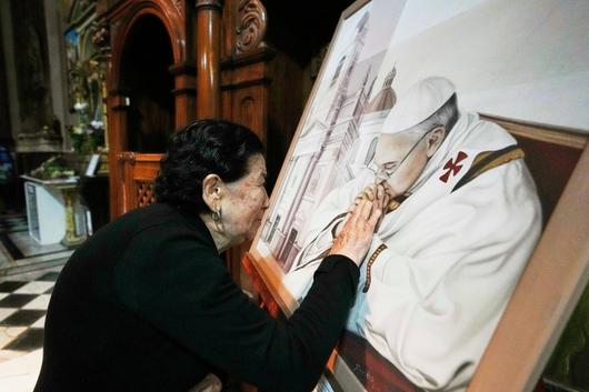 교황청의 프란치스코 교황 선종을 발표한 후 아르헨티나 부에노스아이레스 산 조스 성당에서 한 교구민이  프란치스코 교황의 그림을 어루만지고 있다./AP 연합뉴스