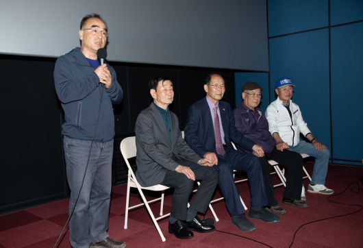 20일 오후 강원도 영월군의 한 극장에서 1980년 정선군 사북읍에서 발생했던 사북사태를 다룬 영화 '1980 사북'을 연출한 박봉남 감독(맨왼쪽)이 영화의 의미를 설명하고 있다. ‘사북사건’ 당시 대치했던 경찰들과 광부가 박 감독의 설명을 들으며 손을 잡고 있다./조인원 기자