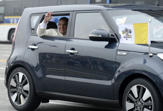 2014년 4박 5일 일정으로 한국을 방문한 프란치스코 교황이 서울공항에서 광화문을 거쳐 주한 교황 대사관으로 향하는 중 기아차 쏘울에 탑승해 시민들을 향해 손을 흔들고 있다./뉴스1