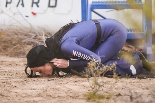 지난 14일 미 민간우주업체 '블루 오리진'의 우주 여행에 참가한 팝스타 케이티 페리가 10분 간의 여행 후 돌아와 땅에 입맞춤하는 모습. /EPA 연합뉴스