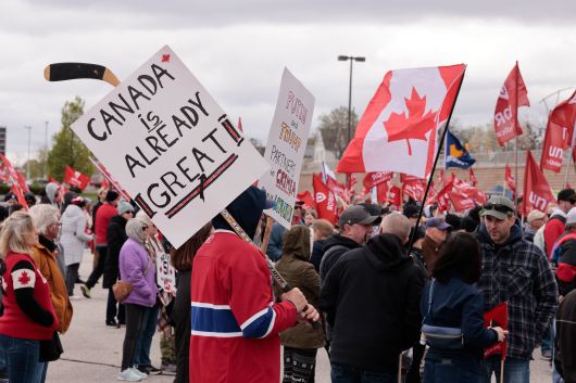 지난달 26일 캐나다 온타리오주에서 미국의 관세 부과에 항의하는 시위대가 캐나다 국기와 피켓을 들고 행진하고 있다. /AFP연합뉴스