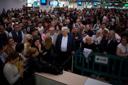 지난달 29일 정전으로 열차 운행이 멈추자 스페인 바르셀로나의 한 기차역 안내 데스크에 모여든 승객들. /AP 연합뉴스