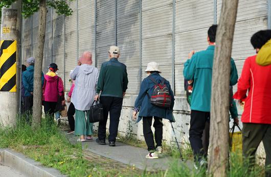 금호타이어 광주공장 화재가 발생한 17일 오후 광주 광산구 소촌동 한 아파트 인근 도로에서 주민들이 대피소로 가는 버스를 기다리고 있다. 광주시와 광산구는 화재로 발생하는 검은 연기의 직접적인 영향을 받는 인접 4개 아파트 단지 주민들을 위해 광주여자대학교 체육관에 대피소를 마련했다./연합뉴스