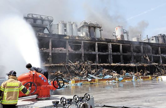 새까맣게 타버린 공장, 가동 전면 중단 - 18일 오후 광주광역시 광산구 금호타이어 광주공장 화재 현장에서 소방대원들이 건물을 향해 물줄기를 쏘고 있다. 불은 17일 오전 7시 11분쯤 발생해 약 32시간 만인 이날 오후 2시 50분쯤 잡혔다. 이틀간 이어진 화재로 약 2만5000㎡ 규모의 건물이 불에 탔고, 공장 직원 1명과 소방대원 2명 등 3명이 다쳤다. 인근 주민 170여 명이 체육관으로 대피하기도 했다. /연합뉴스