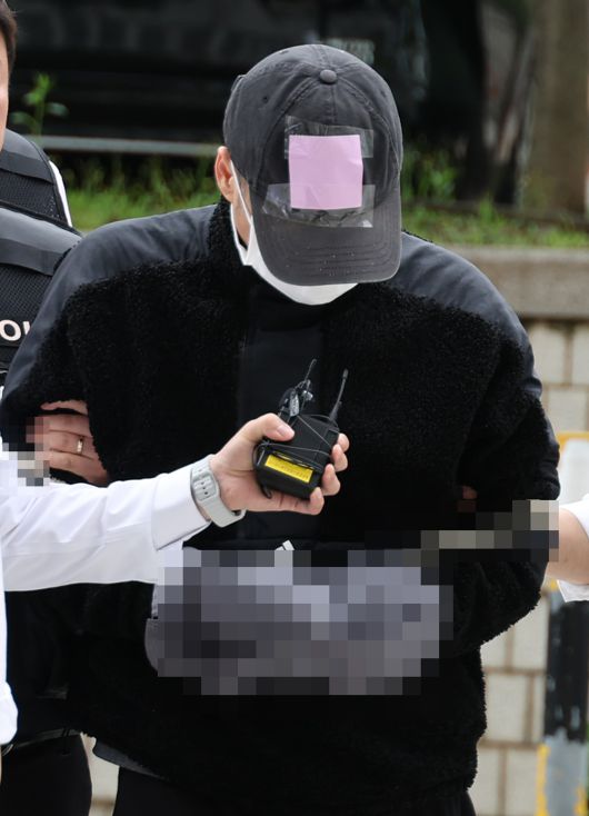 축구 국가대표팀 주장 손흥민을 협박해 돈을 뜰어내려 한 공범 40대 용모씨가 17일 영장실질심사를 받기 위해 서울중앙지법에 들어서고 있다. /연합뉴스