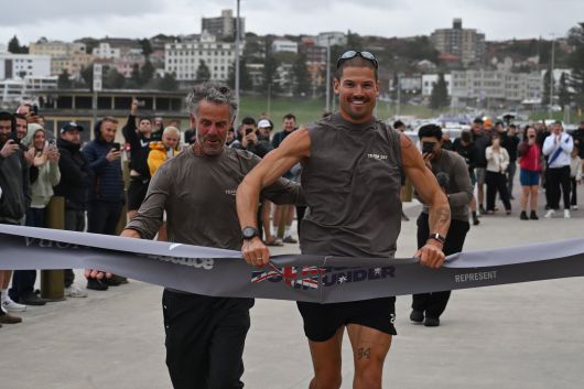 영국의 장거리 육상선수 윌리엄 굿지가 19일 호주 시드니 본다이 비치에서 아버지 그레이엄과 함께 결승선을 통과하는 모습. 굿지는 퍼스 코트슬로 비치에서 시드니 본다이 비치까지 35일 만에 횡단한 신기록을 세웠다. /EPA 연합뉴스