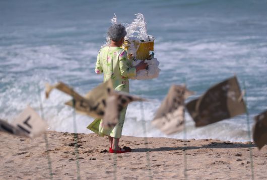 25일 강릉 순포해변 영화 '청명과 곡우 사이' 촬영 현장, 고운 꽃무늬 원피스 차림의 주연 배우 박정자가 자신의 죽음과 떠남을 상징하는 흰 종이상여를 들고 바다로 향하고 있다. /연합뉴스