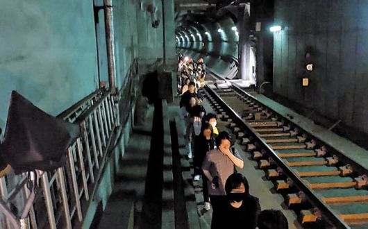 Passengers evacuate through a subway tunnel after a fire broke out on a Seoul Metro Line 5 train on the morning of May 31, 2025. They used emergency door release levers to open the train doors and escaped to a nearby station./Yeongdeungpo Fire Station