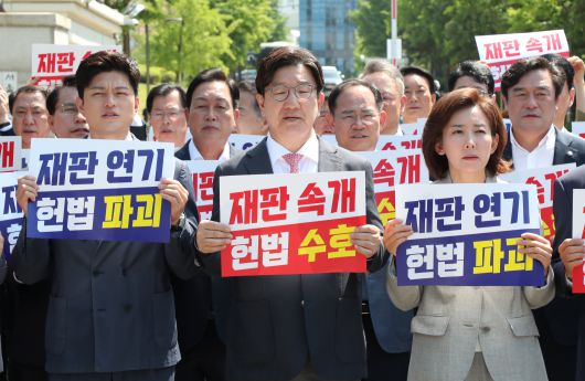 국민의힘 김용태 비상대책위원장과 권성동 원내대표 등 참석의원들이 11일 이재명 대통령의 공직선거법 위반 사건의 파기환송심을 사실상 무기한 연기한 서울고등법원 앞에서 열린 현장 의원총회에서 구호를 외치고 있다. /남강호 기자