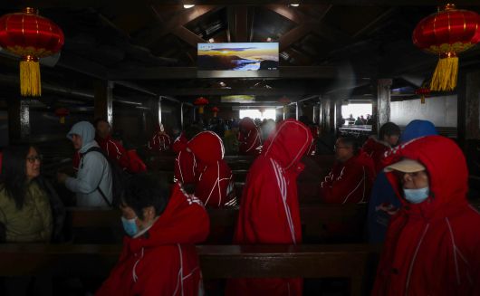 지난 11일 백두산 정상(북파)은 비바람과 안개로 천지를 목격할 수 없었다. 이날 기온은 7도 정도였지만, 강하게 부는 비바람에 체감온도는 영하권에 가까울 정도였다. 대부분의 관광객들은 두꺼운 패딩을 입었다. 사진은 북파 정상에 올랐지만, 안개 등으로 천지를 보지 못한 관광객들이 실망한 채 하산하는 모습. 사진 중간에는 해가 뜬 백두산의 사진이 걸려있다. /박성원 기자