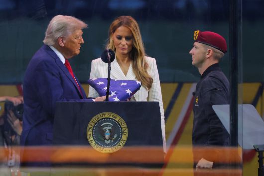 도널드 트럼프 미국 대통령이 지난 14일 미국 워싱턴DC에서 열린 육군 창설 250주년 기념 퍼레이드에서 미 육군 골든나이츠 낙하산 팀원으로부터 성조기를 받고 있다. /로이터 연합뉴스