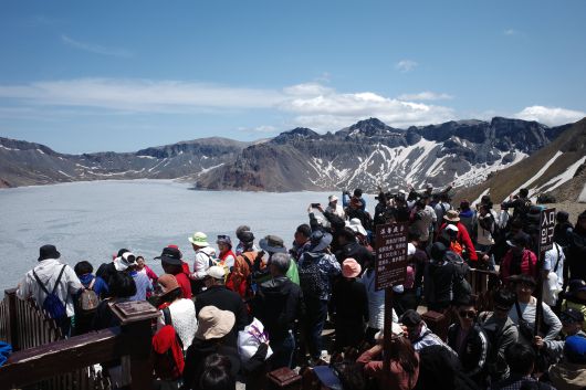 지난 12일 백두산 정상(서파)에 오른 수많은 관광객들이 백두산 천지를 구경하는 모습. /박성원 기자