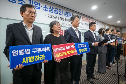 Participants hold signs calling for a freeze on the minimum wage during a press conference by South Korea’s small and medium-sized business community on the 2026 minimum wage, held at the Korea Federation of SMEs in Yeouido, Seoul, on June 23, 2025./Chang Lian-cherng