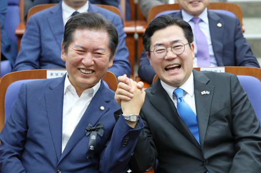 더불어민주당 당대표 출마를 선언한 박찬대(오른쪽), 정청래 의원이 24일 서울 여의도 국회에서 열린 의원총회에서 손을 잡고 포즈를 취하고 있다. /남강호 기자