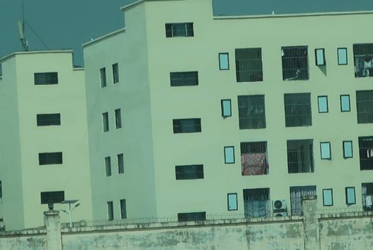 캄보디아의 한 사기 작업장 창문에 쇠창살이 쳐져 있고, 담에는 철조망이 둘러진 모습. /국제앰네스티