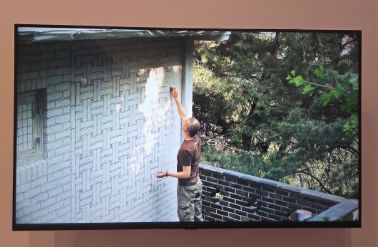 작가가 서울 성북동 한옥집에 종이를 붙이고 흑연으로 문질러 탁본하는 모습. 전시장에서 영상으로 볼 수 있다. /허윤희 기자