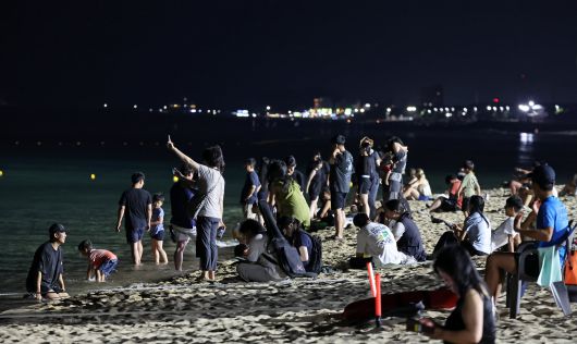 강원 강릉지역에 지난 6월 29일부터 7일째 열대야가 지속되는 가운데 지난 5일 밤 무더위에 잠을 못 이룬 피서객과 시민들이 경포해변에 나와 무더위를 식히고 있다. 이날 밤 강릉의 최저기온은 29.5도를 기록했다. /연합뉴스