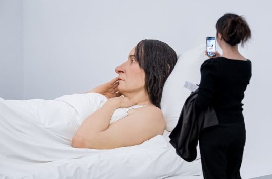 한 관람객이 전시장에서 론 뮤익 작품 '침대에서'를 휴대폰으로 찍고 있다. 침대에 누운 여성을 재현한 가로 6m 대형 조각이다. /국립현대미술관