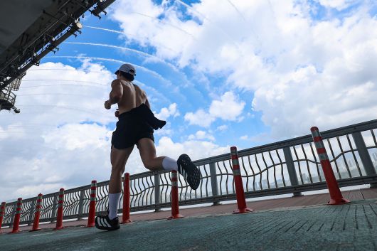 서울 서초구 잠수교에서 한 시민이 무지개분수 아래로 달리고 있다. /연합뉴스