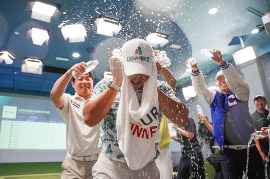 스크린 골프장에서 펼쳐지는 '2025 신한투자증권 G투어' 4차 대회 우승을 차지한 김홍택을 축하하는 선수들. /골프존