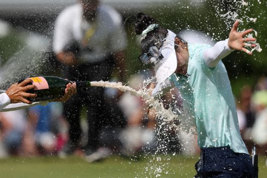 호주의 그레이스 김이 13일(현지시간) 프랑스 동부 에비앙 레뱅의 에비앙 리조트 골프클럽에서 열린 아문디 에비앙 챔피언십 최종 라운드에서  연장 2번째홀에서 이글을 잡으며 우승했다. 동료들이 샴페인을 를 터뜨려 축하해주고 있다. /AFP 연합뉴스