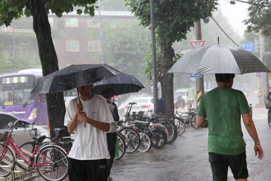 호우주의보에 내려진 18일 광주 북구 용봉동 북구청 일대에 시민들이 우산을 쓴 채 지나가고 있다./뉴스1
