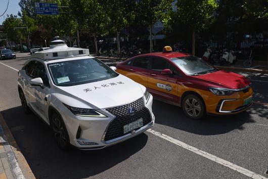 베이징 다싱구에서 택시(오른쪽) 한 대가 무인택시와 나란히 운행하고 있다./EPA 연합뉴스