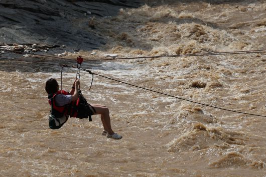 20일 경기 가평군 마일리의 한 캠핑장에 고립된 시민들이 소방 로프를 타고 탈출하고 있다./뉴스1