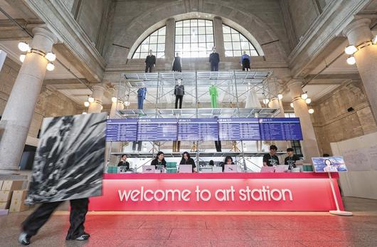 ‘2025 아시아프’가 열리는 옛 서울역사 로비가 거대한 플랫폼으로 변신했다. 열차 출발을 알리는 시간표엔 작가 이름과 작품명이 적혔다. 올해 크리에이티브 디렉터로 참여한 이완 작가의 설치 작품 ‘표준시’다. /고운호 기자