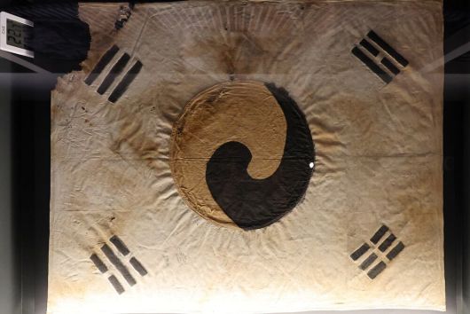 대한민국역사박물관 특별전에 전시된 1900년 파리 만국박람회 출품 추정 태극기(위쪽)와 덕수궁 돈덕전 특별전에 전시된 진관사 태극기./조인원·장경식 기자