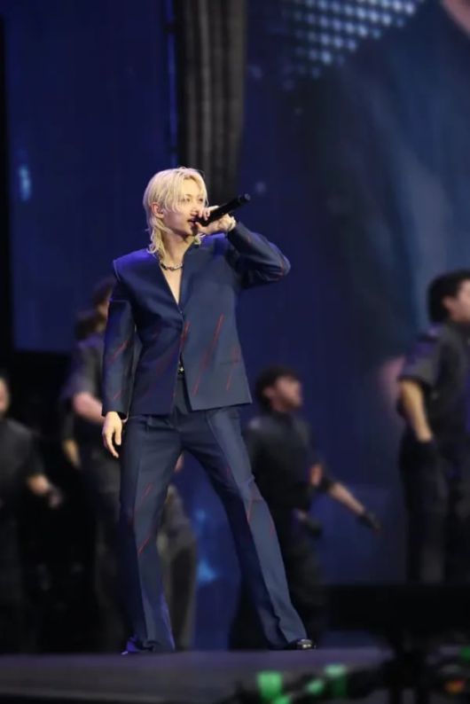 루이 비통의 글로벌 앰버서더 필릭스는 네이비 블루 자카드 실크 V넥 버튼 재킷과 플레어 팬츠로 록 시크의 댄디 룩을 연출했다. 루이 비통.