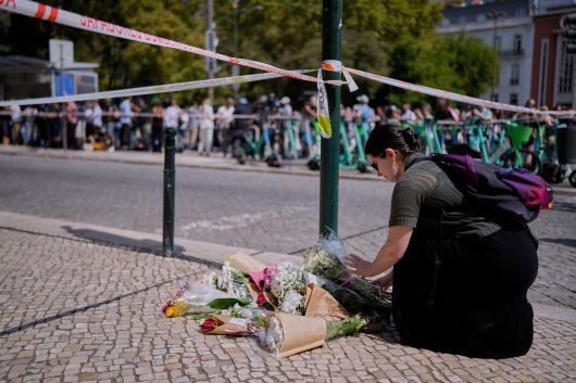 4일 포르투갈 리스본 케이블전차 사고 현장 주변에 한 시민이 헌화하고 있다./AP 연합뉴스