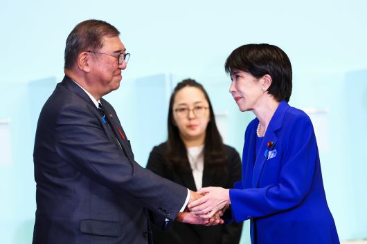 일본 자민당 신임총재로 선출된 다카이치 사나에가 이시바 시게루 총리와 악수하고 있다./ EPA 연합뉴스