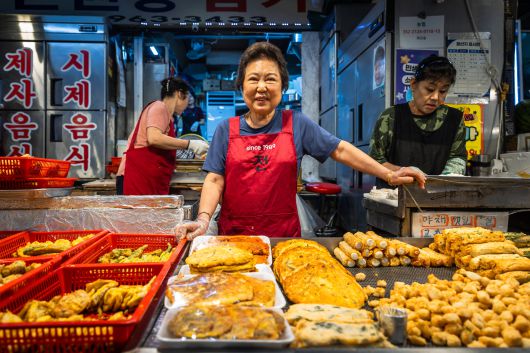 조씨의 사촌 유용화(74)씨가 전을 앞에 두고 웃고 있다. 유씨는 이 자리에 시장이 들어서기 전부터 족발집, 양말 장사 등을 하다가 전집으로 업종을 바꾼 '원조 원당시장 전집 할머니'. /이건송 영상미디어 기자
