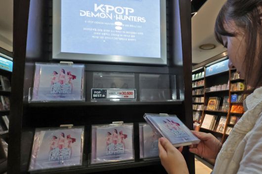지난달 서울 종로구 교보문고 광화문점을 찾은 시민이 케이팝 데몬 헌터스 음반을 살펴보고 있다. /뉴스1