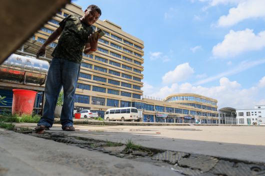 15일 오전 캄보디아 수도 프놈펜 인근에 있는 ‘망고 단지’(왼쪽 사진). 보이스피싱 등 범죄 조직이 활동하는 본거지 중 한 곳이다. 현장 사진을 찍던 본지 기자를 단지 직원으로 보이는 남성이 촬영하고 있다./박성원 기자