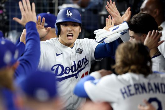 27일 미국 메이저리그 월드시리즈 3차전 경기에서 LA다저스의 오타니 쇼헤이가 토론토 블루제이스를 상대로 타점을 낸 뒤 더그아웃에서 팀 동료 선수들과 손을 맞부딪치고 있다. /AFP 연합뉴스