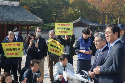 7일 오후 서울 종묘에서 최휘영(오른쪽) 문화체육관광부 장관과 허민(오른쪽 둘째) 국가유산청장이 서울시의 종묘 앞 개발 관련 대법원 판결에 대한 문체부, 국가유산청 입장 발표 기자회견을 열고 있는 가운데 세운4구역 주민들이 피켓 시위를 하고 있다. /장련성 기자