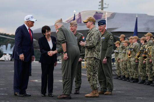 다카이치 사나에(왼쪽에서 둘째) 일본 총리가 지난달 28일 가나가와현 요코스카 미군 기지에 정박 중인 미 항공모함 조지워싱턴함 갑판에 올라 군 관계자와 악수하는 장면을 도널드 트럼프 미국 대통령이 지켜보고 있다. 다카이치는 이날 “평화는 말이 아닌, 확고한 결의와 행동에 의해서만 지켜진다”고 했다./AP 연합뉴스