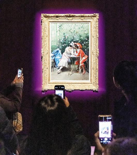3일 서울 용산 국립중앙박물관 전시장에서 관람객들이 스페인 화가 라이문도 데 마드라소 이 가레타의 유화 ‘가면무도회 참가자들’을 휴대폰에 담고 있다. 가장무도회에 참가한 남녀가 햇빛 비치는 온실에서 잠시 둘만의 시간을 즐기는 모습을 묘사한 그림이다. 101.6×64.8cm. /김지호 기자