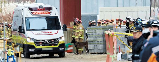 지난 13일 광주광역시 도서관 공사장 붕괴 사고 현장에서 구조대가 마지막 매몰자의 시신을 수습해 나오고 있다. 대원들이 구급차를 향해 경례하고 있다./연합뉴스