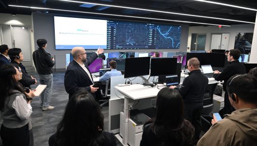 모셔널 운영 담당 애덤 그리핀 부사장이 라스베가스 테크니컬 센터 안에 있는 관제센터에서 앞쪽 모니터 화면을 가리키며 시스템을 소개하고 있다. 현재 로보택시 시범 운영 중인 미국 라스베이거스, 피츠버그 도시를 달리는 차량 데이터를 실시간 모니터링한다./현대차그룹