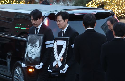 배우 정우성과 이정재가 故 안성기의 장례 미사를 위해 9일 오전 서울 중구 명동성당으로 들어서고 있다. 정우성은 고인의 영정을, 이정재는 금관문화훈장을 들고 있다. /뉴스1