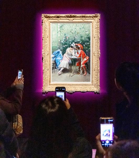 서울 용산 국립중앙박물관 전시장에서 관람객들이 스페인 화가 라이문도 데 마드라소 이 가레타의 유화 ‘가면무도회 참가자들’을 휴대폰에 담고 있다. 가장무도회에 참가한 남녀가 햇빛 비치는 온실에서 잠시 둘만의 시간을 즐기는 모습을 묘사한 그림이다. 101.6×64.8cm. /김지호 기자