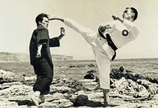 미국 ‘태권도의 대부’ 이준구(오른쪽) 전 사범이 생전 이소룡에게 발차기를 하고 있는 모습. /위키피디아