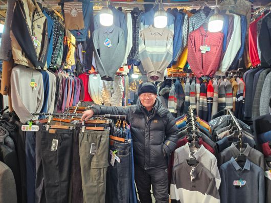 8일 오후 2시쯤 서울 중구 남대문시장에 위치한 남성복 전문점 ‘대도사’의 사장 이경복(66) 씨가 옷걸이 사이에서 포즈를 취하고 있다./지혜진 기자