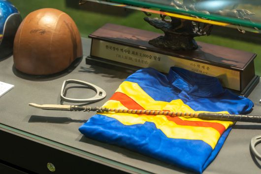 박태종 기수의 은퇴 특별전에 전시된 그의 트레이드마크 기수복과 채찍, 재갈과 2000승 기념패 등. /이신영 영상미디어기자