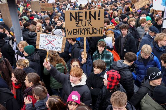 지난 달 5일 독일 베를린에서 병역 의무화 반대 시위 당일 한 사람이 '병역 의무화 반대'라고 적힌 팻말을 들고 있다. /로이터 연합뉴스